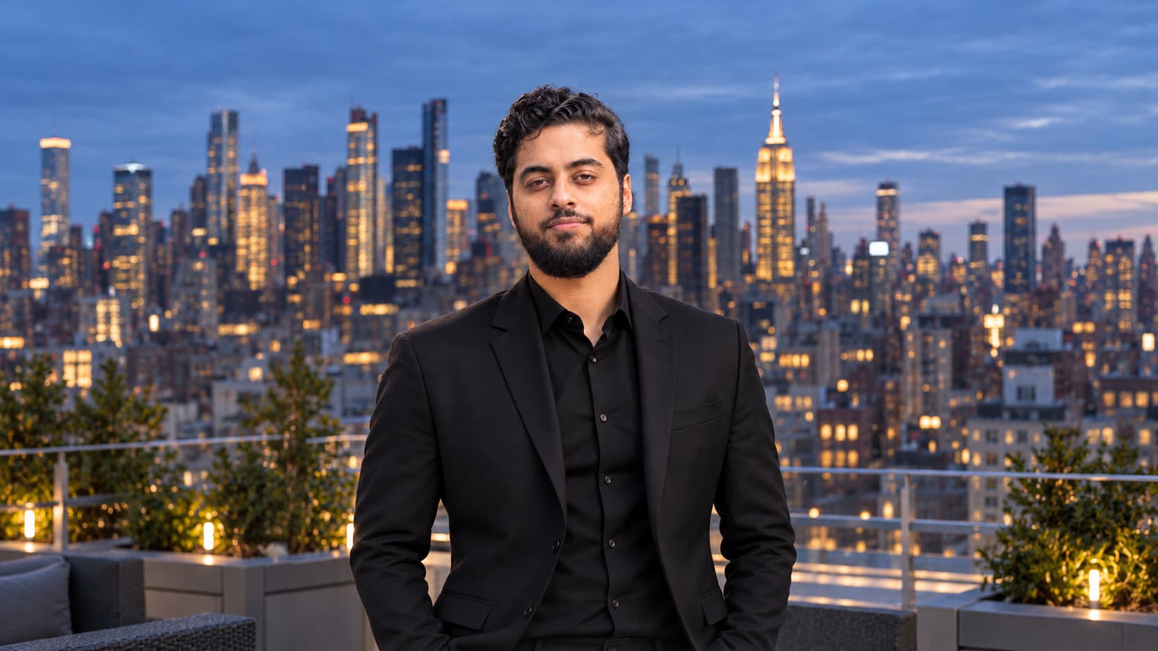 Zaid Aslam, licensed Property & Casualty insurance professional and front-end web developer, on a rooftop with the New York City skyline at dusk