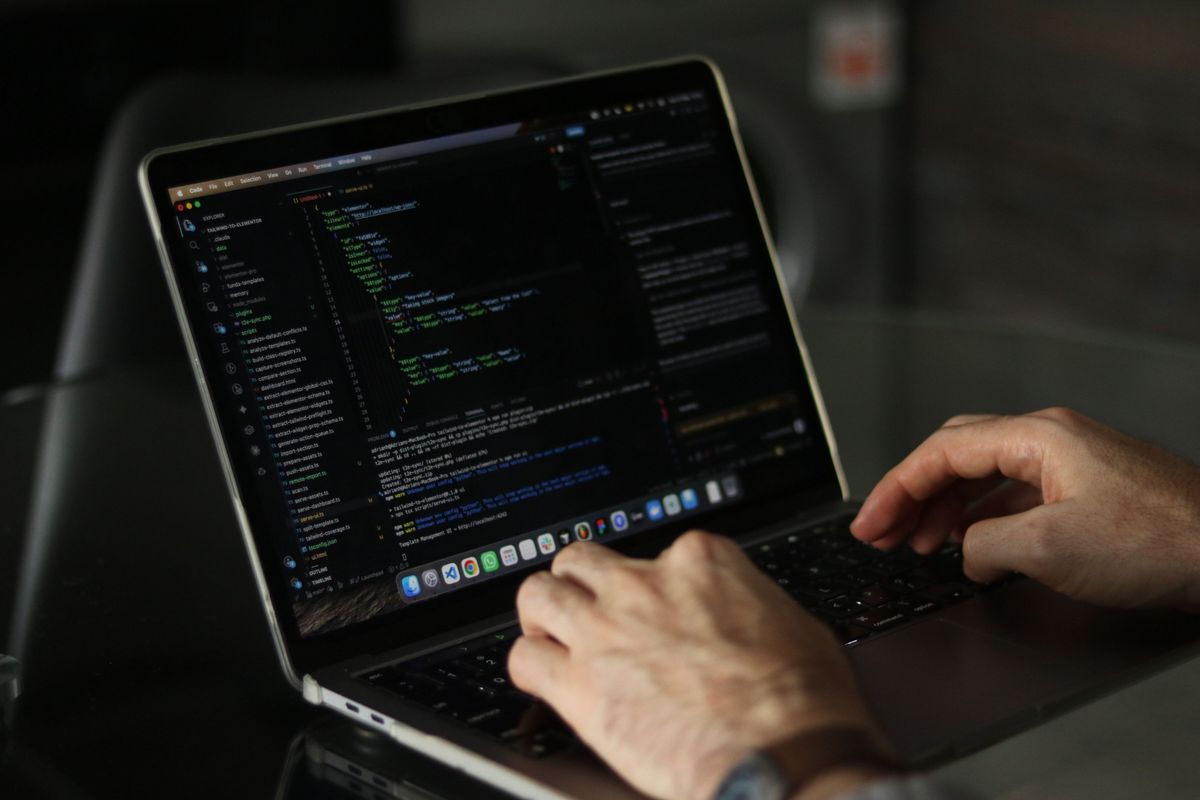 Front-end web developer writing JavaScript and React code on a laptop